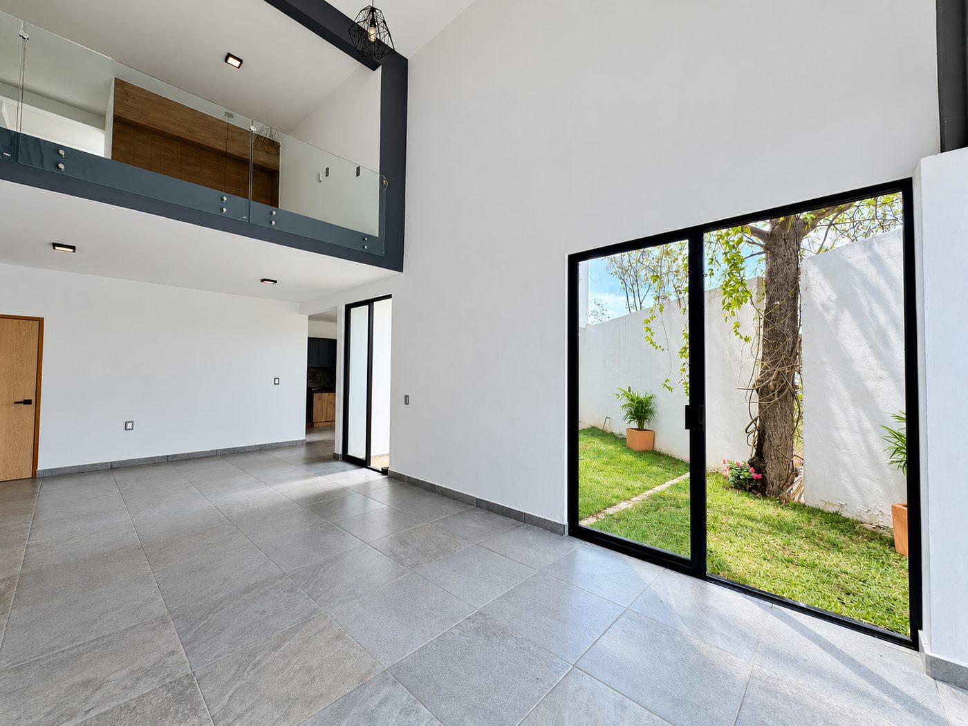 Sala de doble altura con vista al jardín
